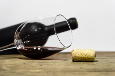 Bardak beyaz şarap bir yuvarlak masa üzerinde siyah bir şişe şarap. Güzel beyaz arka plan