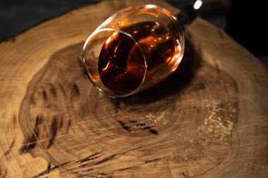 Bardak beyaz şarap bir yuvarlak masa üzerinde siyah bir şişe şarap. Güzel beyaz arka plan