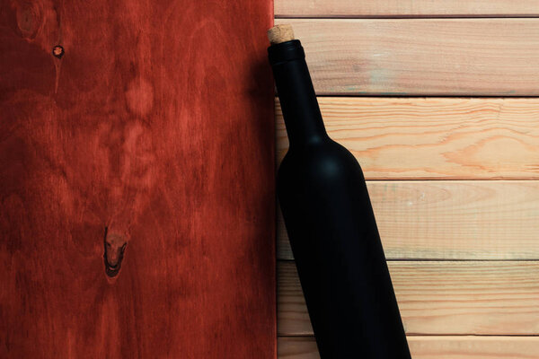 Black bottle of red wine on a wooden table. Beautiful  background