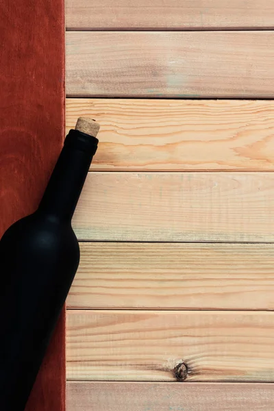 Siyah şişe kırmızı şarap ahşap bir masa üzerinde. Güzel arka plan