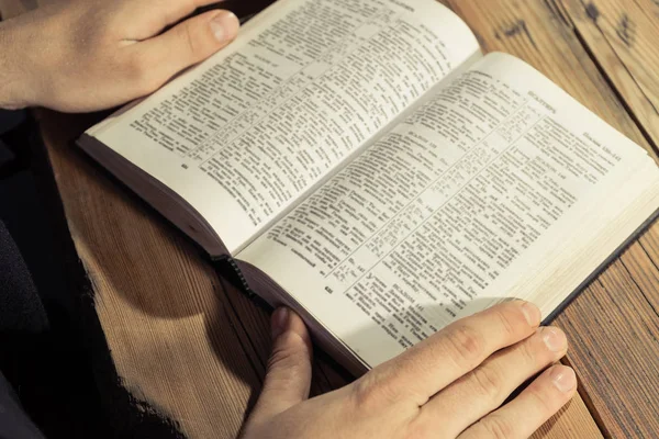 Mann Sitzt Einem Alten Eichentisch Und Liest Die Heilige Bibel Stockfoto