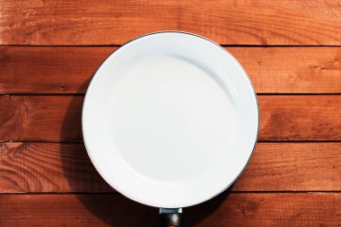 Tablo arka plan üzerinde beyaz büyük kızartma tavası