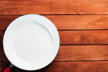 Tablo arka plan üzerinde beyaz büyük kızartma tavası