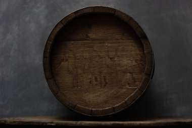 Varil üzerinde eski bir yuvarlak ahşap masa. Güzel koyu arka plan