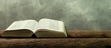 Kutsal İncil'in eski meşe ahşap bir masa üzerine. Güzel turuncu arka plan. Din kavramı.