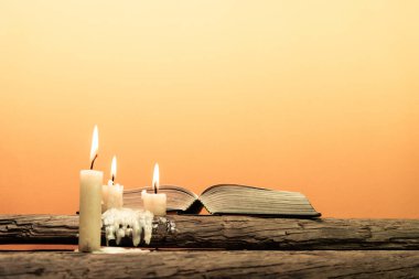 Kutsal İncil'in eski meşe ahşap bir masa üzerine. Güzel turuncu arka plan. Din kavramı.