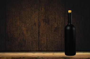 Eski meşe masa ve arka plan duvar siyah şarap şişesi.