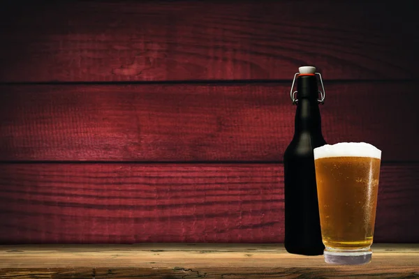 Glass of beer on a old oak table and background