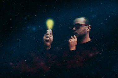 Kırmızı glasess loking ışık bulbd genç adam.