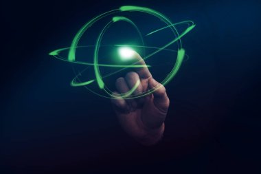 İnsan işaret parmağı yeşil atom dokunur. Karışık teknik.