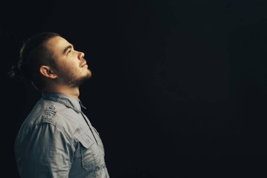 Genç adam bir siyah arka plan üzerine ararken.