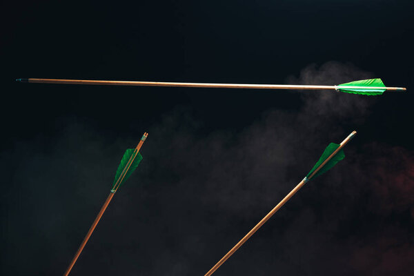 Три деревянные стрелы один летит. Красивый смога фон. Средневековое оружие ручной работы
.