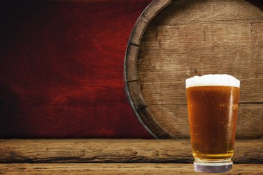 Ahşap varil ve bardak bira eski meşe masada tahta üzerinde.