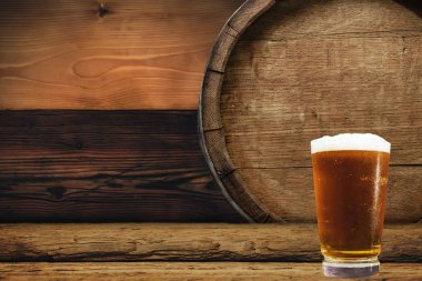 Ahşap varil ve bardak bira eski meşe masada tahta üzerinde.