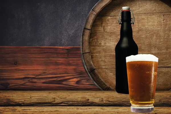 Wooden barrel and glass of beer on a old oak table of wood.