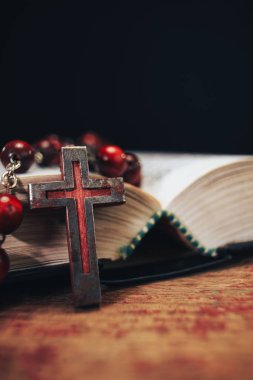 Eski kırmızı boncuk ve İncil'de arka plan üzerinde haç. Makro görünümü.