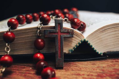 Eski kırmızı boncuk ve İncil'de arka plan üzerinde haç. Makro görünümü.