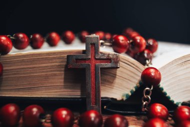 Eski kırmızı boncuk ve İncil'de arka plan üzerinde haç. Makro görünümü.