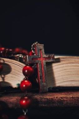 Eski kırmızı boncuk ve İncil'de arka plan üzerinde haç. Makro görünümü.