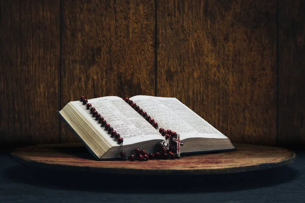 聖書と旧円卓の十字架ビーズ 美しい茶色の木製の背景 宗教概念 — ストック写真
