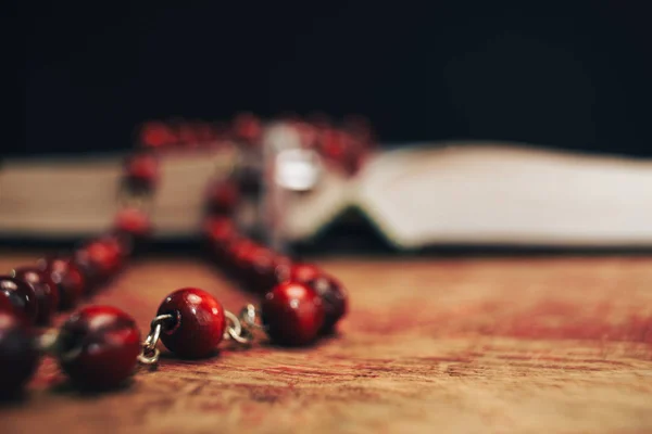 Manik Manik Merah Tua Dan Salib Pada Latar Belakang Alkitab — Stok Foto