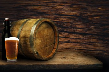 Ahşap varil ve bardak bira eski meşe masada tahta üzerinde.