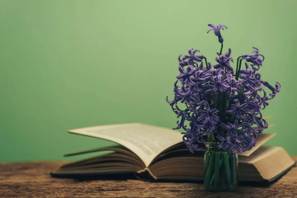 Öppna Boken Och Lila Blomma Gammal Träbord Gröna Väggen Bakgrund — Stockfoto