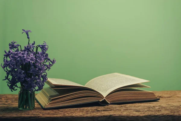Open Book Purple Flower Old Oak Wooden Table Green Wall — Stock Photo, Image