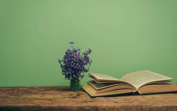 Open Book Purple Flower Old Oak Wooden Table Green Wall — Stock Photo, Image