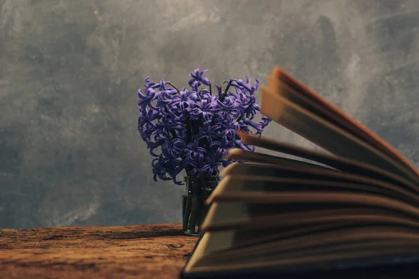 Open Book Purple Flower Old Oak Wooden Table Gray Wall — Stock Photo, Image