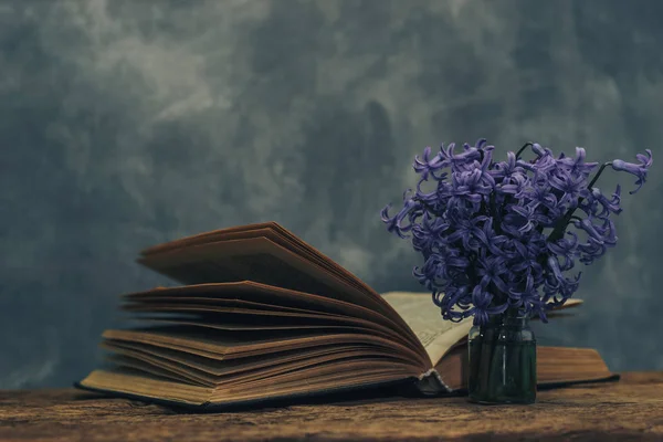 Open Book Purple Flower Old Oak Wooden Table Gray Wall — Stock Photo, Image