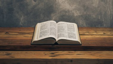 Kutsal İncil 'i eski bir meşe ağacından masanın üzerinde aç. Gri duvar arka planı.