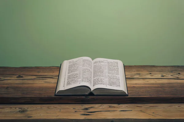 Die Bibel Auf Einem Alten Eichentisch Aufschlagen Grüne Wand Hintergrund — Stockfoto