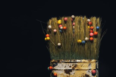 Koyu arka planda fırça ve çok renkli topları.