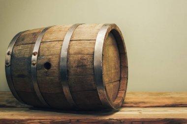 Eski bir meşe masasında ahşap varil. Arkasında yeşil arka plan.