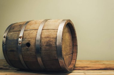 Eski bir meşe masasında ahşap varil. Arkasında yeşil arka plan.