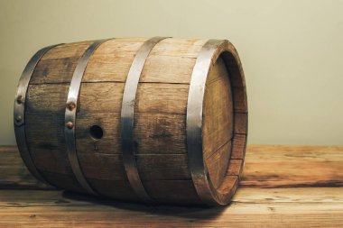 Eski bir meşe masasında ahşap varil. Arkasında yeşil arka plan.