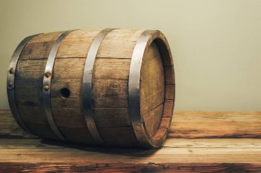 Eski bir meşe masasında ahşap varil. Arkasında yeşil arka plan.