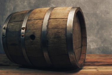 Eski bir meşe masasında ahşap varil. Arkasında gri arka plan.