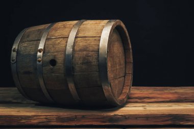 Eski bir meşe masasında ahşap varil. Arkasında siyah arka plan.