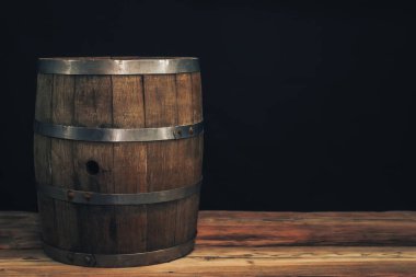 Eski bir meşe masasında ahşap varil. Arkasında siyah arka plan.