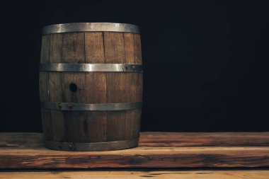 Eski bir meşe masasında ahşap varil. Arkasında siyah arka plan.