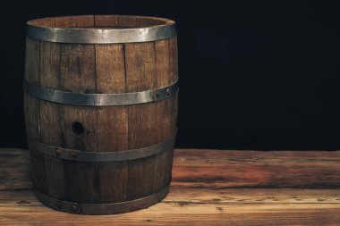 Eski bir meşe masasında ahşap varil. Arkasında siyah arka plan.