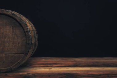 Eski bir meşe masasında ahşap varil. Arkasında siyah arka plan.