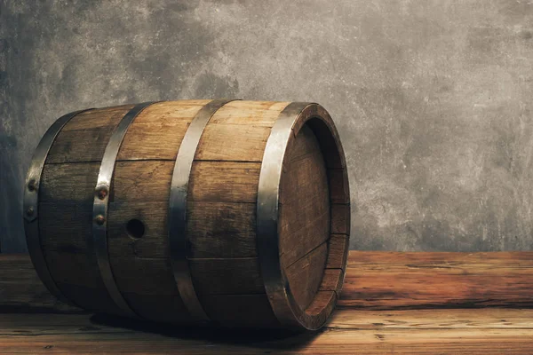 Wooden barrel on a old oak table. Gray background behind.