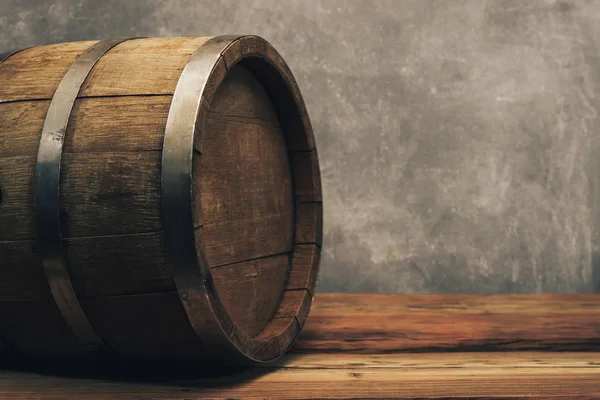 Eski bir meşe masasında ahşap varil. Arkasında gri arka plan.