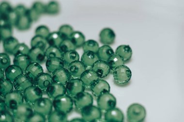 Beyaz arka planda yeşil cam boncuk. Makro görünümü.