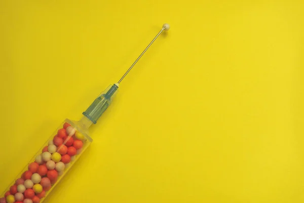 Şırınga Sarı Bir Arka Plan Üzerinde Renkli Nano Topları Ile — Stok fotoğraf