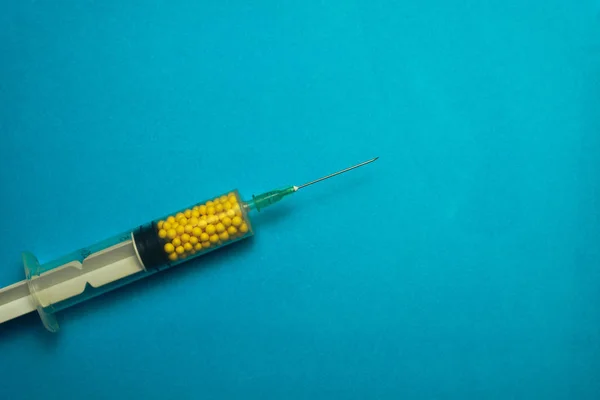 Syringe Filled Yellow Nano Balls Blue Background Innovative Medical Concept — Stock Photo, Image