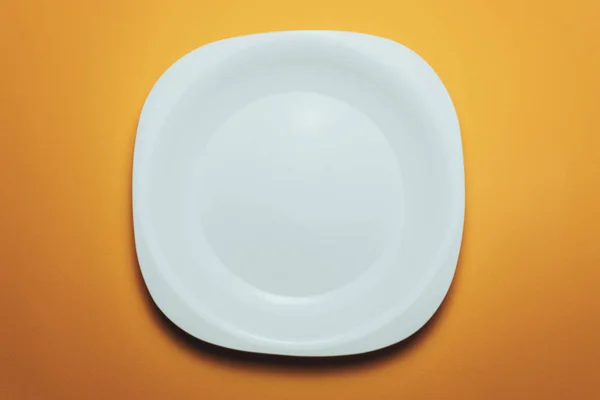 白色的碗和一个叉子 背景是橙色的勺子 — 图库照片